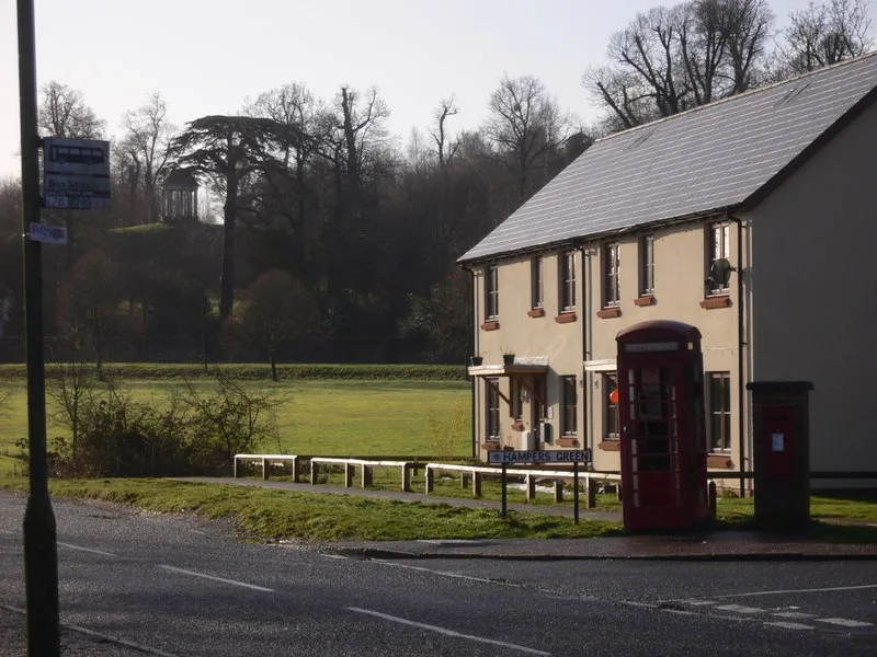 Hampers Green in Petworth, with the green behind a row of houses and a red telephone box