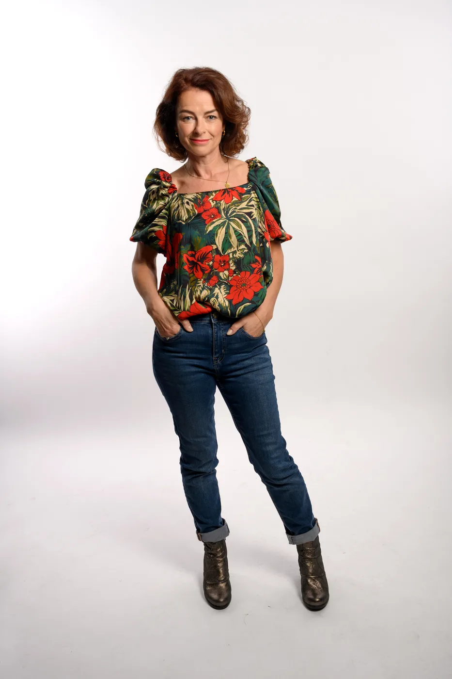 Annabelle Dowler in a floral top and jeans against a white studio background